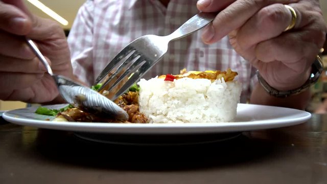 Close up man eating garlic pork rice and fried egg : Famous Thai street foods