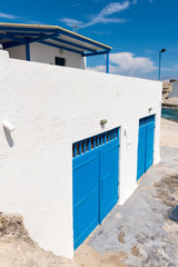 Fototapeta na wymiar Typical boat houses (sirmata) in Agios Konstantinos, a small fishing port and a beach on Milos island. Cyclades, Greece. 