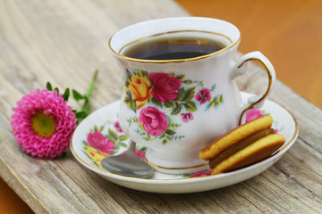 Obraz na płótnie Canvas Cup of black tea in vintage porcelain cup with Japanese cookie and daisy flower 
