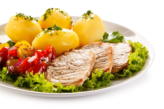 Grilled pork chops, boiled potatoes and vegetable salad 