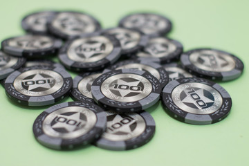 A lot of chips for playing poker on a green background. Top view of a close-up
