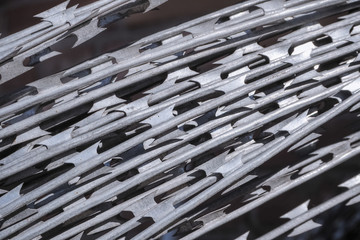 Barbed wire twisted into a coil in an industrial warehouse. Close-up.
