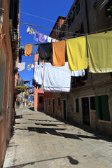 VENICE - APRIL 10, 2017: The view on alley in Venice. Laundry drying in the sun over alley in Venice Italy, on April 10, 2017 in Venice, Italy