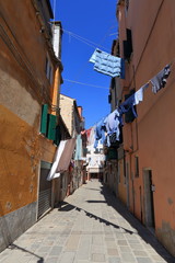 VENICE - APRIL 10, 2017: The view on alley in Venice. Laundry drying in the sun over alley in Venice Italy, on April 10, 2017 in Venice, Italy