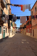 VENICE - APRIL 10, 2017: The view on alley in Venice. Laundry drying in the sun over alley in Venice Italy, on April 10, 2017 in Venice, Italy