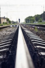 Fototapeta na wymiar Silhouette of a man walking on rails of a train