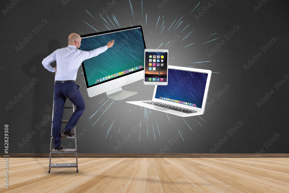 Poster businessman in front of a wall with computer and devices displayed on a futuristic interface - multi