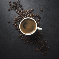 Cup of coffee and beans on table