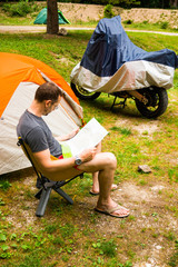 Fototapeta premium Man with map next to Camping Tent in nature