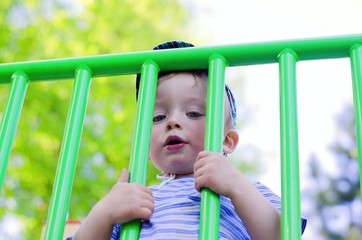 Obraz premium Little sad boy behind a fence.. Child concept.