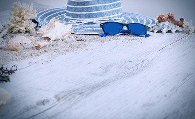 Sand and shells and hat on the wooden floor, summer concept