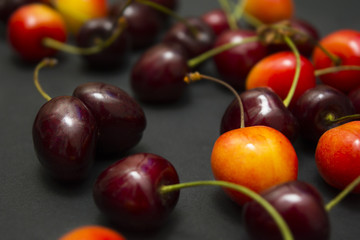 Ripe red and orange cherry on a dark background.