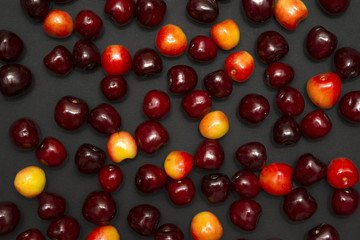 Ripe red and orange cherry on a dark background.