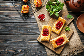 Cutting board and baking rack with pastries on wooden table