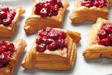 Tray with delicious puff pastries and cherry, closeup