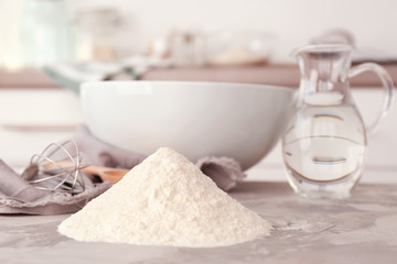 Heap of flour and kitchenware on light table