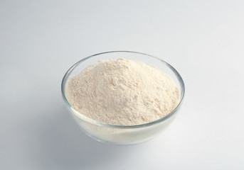 Bowl with flour on white background