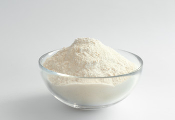 Bowl with flour on white background
