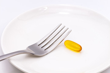 Pills on white plate with fork. Pill instead of food. diet