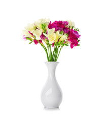 Bouquet of beautiful freesia in vase on white background