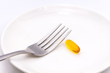 Pills on white plate with fork. Pill instead of food. diet