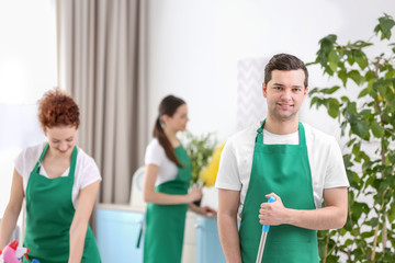 Cleaning service team working in living room