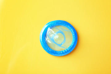 Blue condom on color background. Safe sex concept