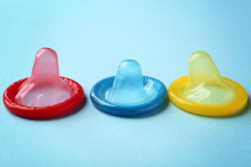 Colorful condoms on blue background.  Safe sex concept