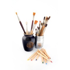 Colored pencils and brushes in various angles on a white background