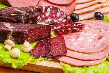 Meat and knife on the background of lettuce, cultivated mushrooms, olives in various angles