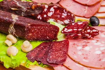 Meat and knife on the background of lettuce, cultivated mushrooms, olives in various angles