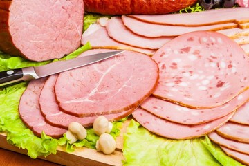 Meat and knife on the background of lettuce, cultivated mushrooms, olives in various angles