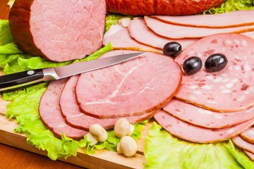 Meat and knife on the background of lettuce, cultivated mushrooms, olives in various angles