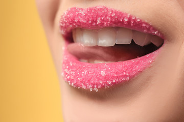 Woman with sugar lips on color background