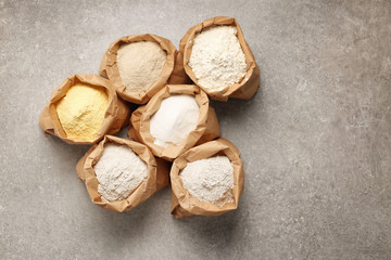 Paper bags with different types of flour on table