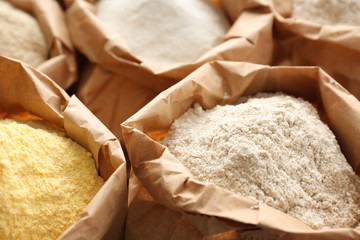 Paper bags with different types of flour, closeup