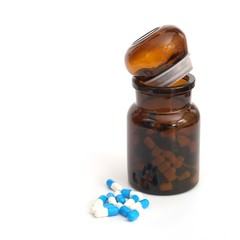 Bottles and medicine in capsules on a white background