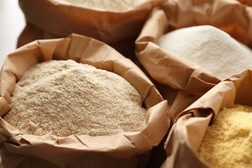 Paper bags with different types of flour, closeup