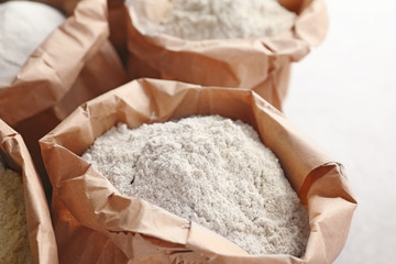 Paper bags with different types of flour, closeup