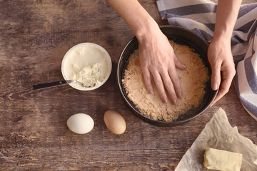 Woman preparing cheese cake in kitchen
