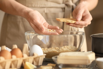 Obraz na płótnie Canvas Woman preparing dough for cheese cake in kitchen
