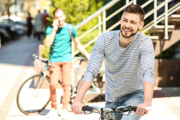 Obraz premium Handsome young man with bicycle outdoors on sunny day