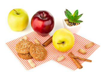 Apples, peanuts and oatmeal cookies on a white table