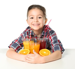 Cute little girl with glasses of different juice on white background