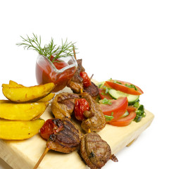 close up duck kebabs with sause, potatoes and vegetables on skewer