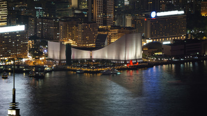 Fototapeta premium Hong Kong Victoria harbour and its iconic red ancient junk sail zoom shot from the Peak at night