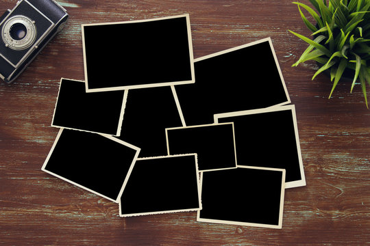 top view of blank photo frames on wooden background