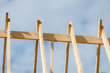 Obraz premium The rafters of the roof of the new wooden house under construction