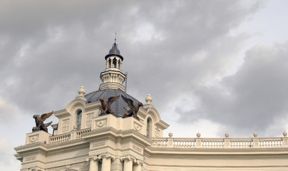 Fototapeta na wymiar beautiful old building with gargoyles on a background of dark sky with storm clouds