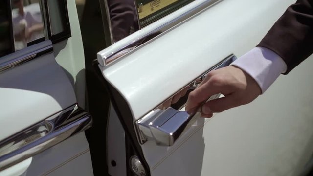 Man opening door of luxury car at sunny day